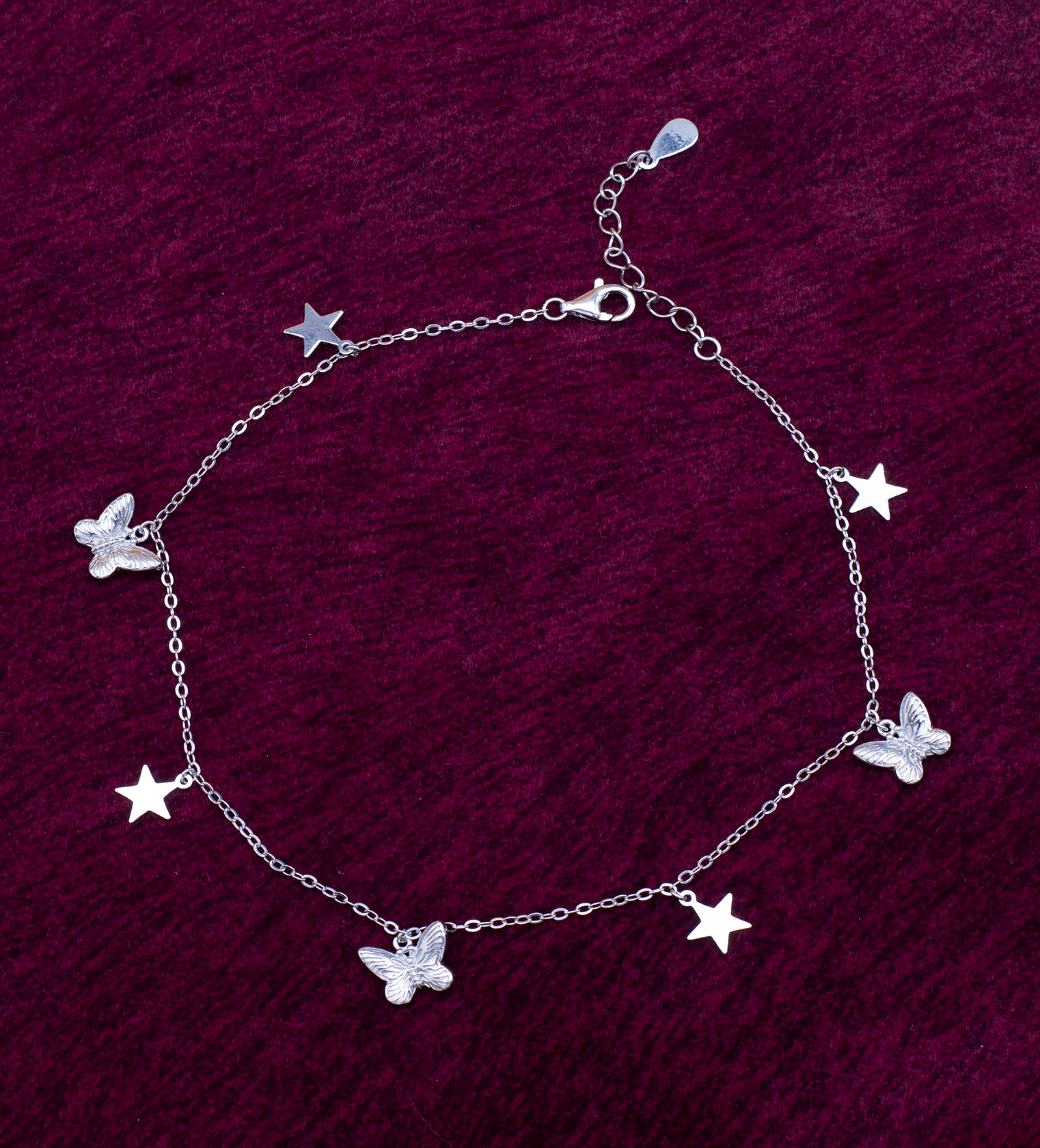925 sterling silver butterfly and star charm anklet on dark velvet background — Ross Jewells India ₹5,850 925 sterling silver butterfly and star charm anklet on dark velvet background — Ross Jewells India ₹5,850